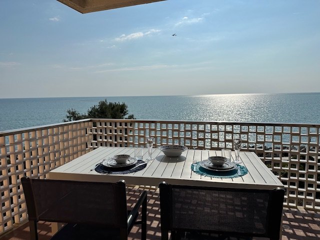 Terrazza fronte mare con tavolo da pranzo e vista sul mare aperto di Grado
