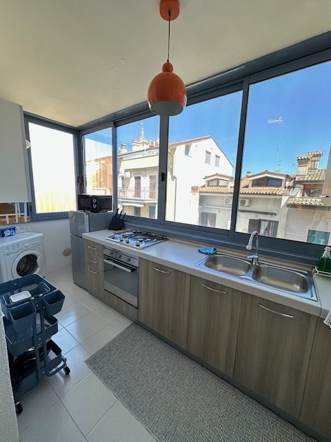 Cucina luminosa con grande finestra affacciata sul mare e sui tetti di Grado